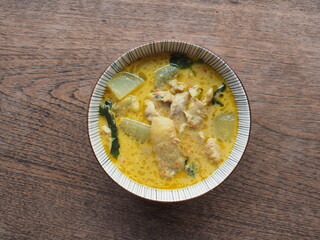 Top view bowl of Thai green curry on wooden table