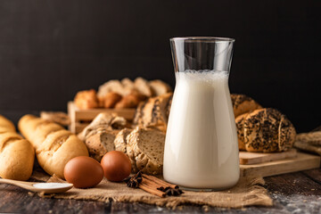 Milk in a glass bottle placed on a wooden table with ingredients