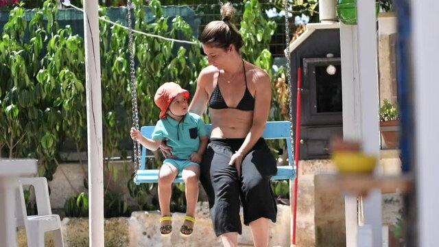 Mother and son swinging on the swing in a scene of tenderness