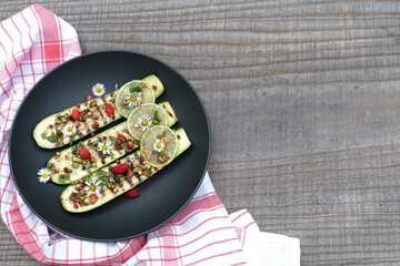 Grilled sliced zucchini salad with daisy flowers and wild strawberry.