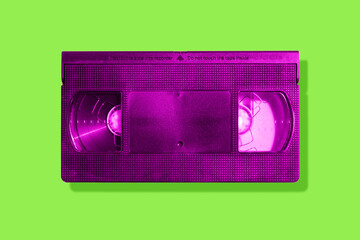 Pink VHS tape on a neon green background with shadow