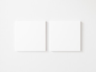 Two square empty canvas frame on white wall. 3d illustration.