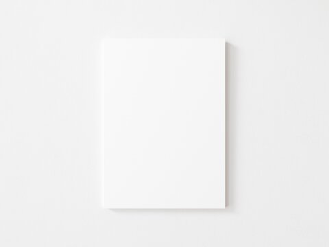 Empty vertical canvas frame on white wall. 3d illustration.