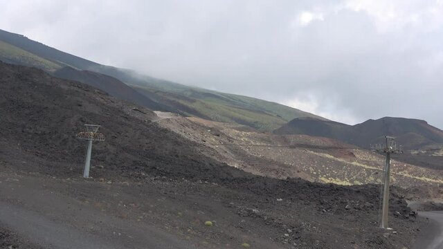 Picturesque volcanic landscape of Mount Etna view from cableway, Etna national park, Sicily, Italy. Smoke and clouds, footage in 4k