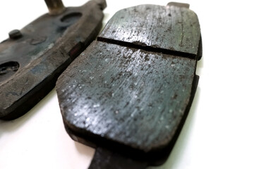 Worn out brake pad or brake shoes, component showing steel backing plates with friction material...