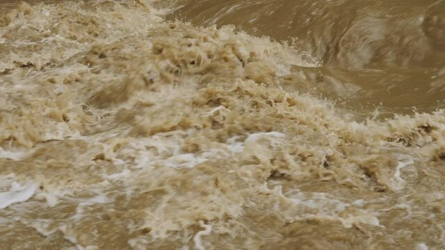 Dirty water stream. Raging river with dirty water after rainfall. Natural disasters, extreme weather.