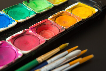 Colorful of Watercolor palette and paintbrush  on a black background