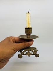 Candle in a candlestick, vintage candle holder on a white background