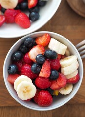 OLYMPUS DIGITAL CAMERA Fruit salad in bowl with blueberries, strawberries and banana.