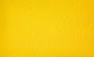 Colorful yellow paint texture on cement wall abstract background