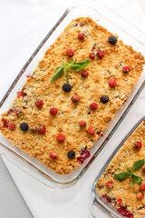 Ruddy crumble with field strawberries, decorated with a sprig of mint
