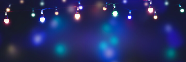 bunte lichterketten in einer reihe in der nacht, magischer hintergrund banner für feiertage mit werbefläche - obrazy, fototapety, plakaty