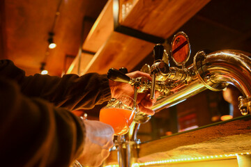 Pouring beer. Cropped image of bartender poring beer into the beer glass.