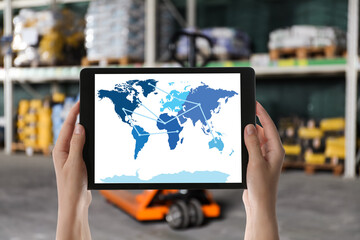 Wholesale trading. Woman tablet with world map illustration at warehouse, closeup