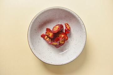 Tasty oriental sweets, dessert churchkhela, cut and served in a white plate over bright pastel background.