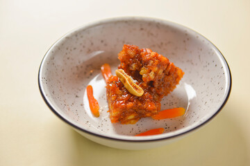 Novey and nuts dessert. Sweet caramel dessert in a bowl over pastel yellow background. Delicious tasty food.