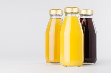 Yellow, red fruit and berries juices collection in glass bottles with cap, group, closeup mock up...