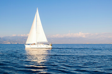 Fototapeta na wymiar Racing yacht in the sea on blue sky background. Peaceful seascape. Travel concept, travelling.