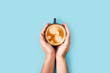 Top view of coffee in cup on blue background. Morning coffee time