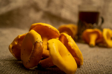 A pile of curly cookies in the form of chanterelle mushrooms on a homespun fabric with a rough texture. Close up.