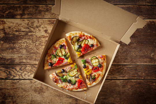 Sliced Italian pizza in a cardboard fast food box