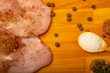Meat steaks and various spices on a wooden Board. Close up.