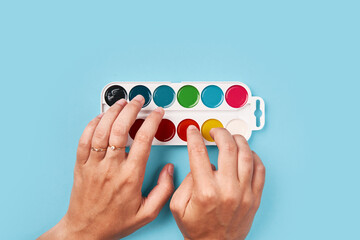 top view of woman hands playing on paint. creativity concept.