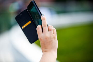 A woman holds a smartphone with her middle finger out