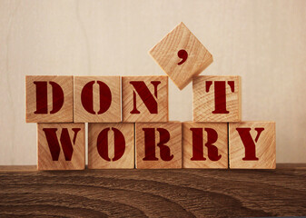 Don't Worry text made of wooden cubes on oak table edge. New normal concept