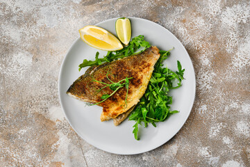 Fried dorada fish with fresh arugula