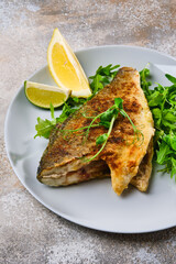 Fried dorada fish with fresh arugula