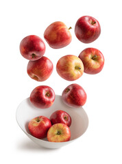 Apples flying over white bowl isolated from the background