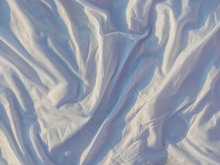 fabric texture, beach fabric, white sheet on the beach with sun glare and waves
