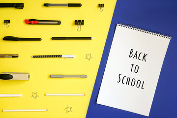Stationery on yellow. Flat lay. Rows of tools, gradient colors. Blue background and note with text Back to school.