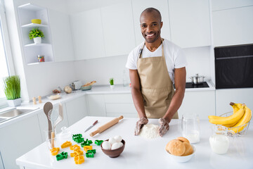 Portrait of his he nice attractive cheerful cheery guy making pizza pie dessert healthy farm organic ingredients doughing flour in modern light white interior house kitchen