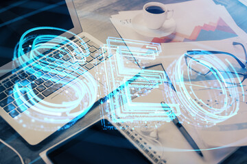 Double exposure of table with computer and seo drawing hologram. Search optimization concept.