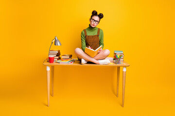 Full length photo minded girl sit table legs crossed write note book think thoughts brainstorm project look copyspace wear green jumper skirt overall isolated bright shine color background