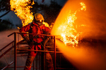 Firefighters using water fog spraying down fire from oil rig factory explosion