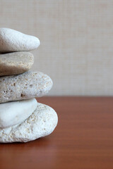 Fototapeta na wymiar pyramid of round natural stones on a wooden background