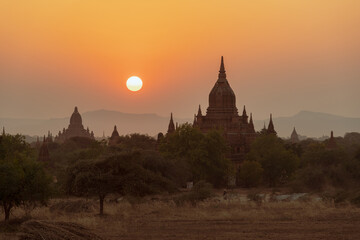 Sunset over ancient temples, pagodas and stupas in Old Bagan, Myanmar Peaceful Asian landscape with Buddhist temple silhouettes. Sacred, serene sky and beautiful scenery.