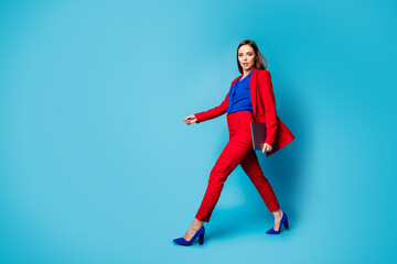 Fototapeta na wymiar Full length body size profile side view of her she nice-looking attractive pretty gorgeous luxury office lady walking carrying laptop isolated over bright vivid shine vibrant blue color background