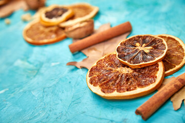 Autumn composition background with slices of dried oranges, leaves and cinnamon on a blue background, autumn concept, flat lay, top view