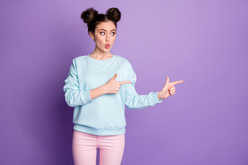 Portrait of astonished girl youth point index finger copyspace demonstrate discount ads pick tips wear trousers isolated over violet color background