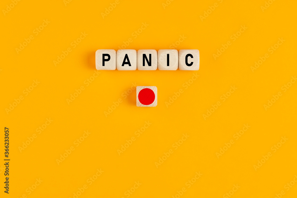 Poster the word panic written on wooden cubes with a red push button. panic button concept.