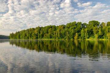 summer morning landscape on the lake, beautiful clouds and wonderful reflections in the lake mirror, summer morning by the water