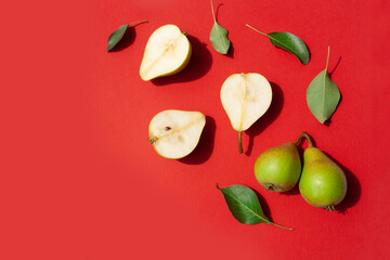 Ripe pears on a red background. Flat lay style