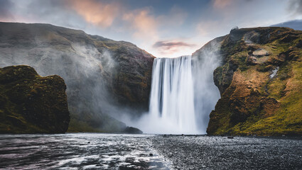 Icelandic Landscape. Classic long exposure view of famous Skogafoss waterfall with colorful sky during sunset. Skoga river, highlands of Iceland, Europe. Popular Travel destinations. Amazing nature.
