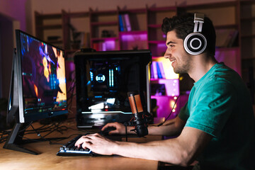 Image of caucasian happy man playing video game on computer