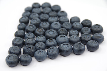 Blueberries heart isolated on a white background. Fresh blueberry wallpaper.