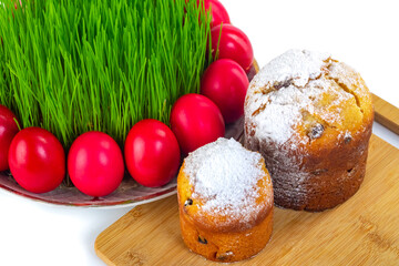 Red Easter eggs around wheat grass on the plate isolated on white, Ester cake